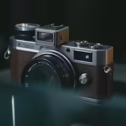 a silver and brown digital camera sitting on top of a table