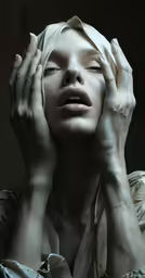 woman in white clothes sitting and holding hands on both sides of her head