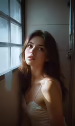 a woman is sitting down in front of the window