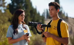 two people are looking at a digital camera