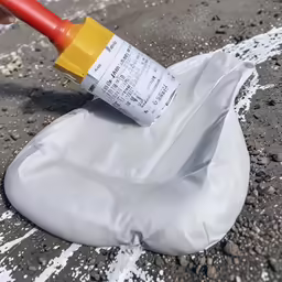 a red and yellow marker sitting on a white sheet of cloth