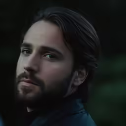 a man with long hair and a leather jacket