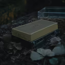 a video recorder lying on the ground surrounded by leaves