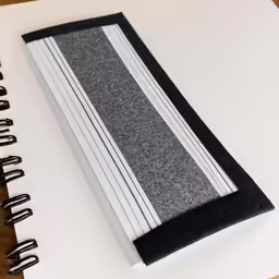 the notebook is made of paper and has an open page with black trim