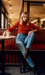a woman sitting on a table near a red booth