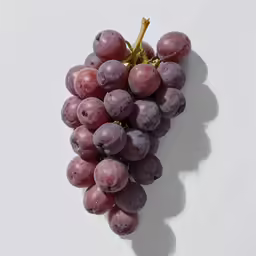 a bunch of grapes on a white table