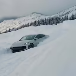 the car is driving on the snow covered hill