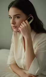 the woman is talking on her phone while laying down