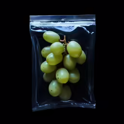 a plastic bag filled with a bunch of green grapes