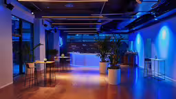 a reception area that looks like it is lit with lights,the interior of an office with wood floors and plants