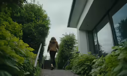 the woman is walking down the stairs towards her window