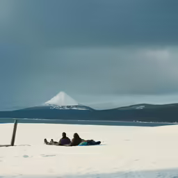 people laying on the snow under a cloudy sky