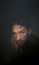 a man is in the dark with light pouring over him