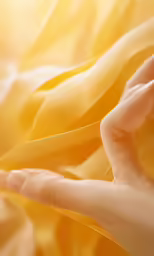 hand with extended fingers reaching toward sunlight through curtains