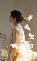a woman in a white top with a bird cage