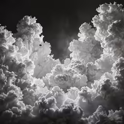 several clouds are seen over a dark background
