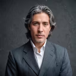 a close up of a person wearing a suit and tie