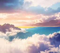 a landscape with mountains and a body of water,the clouds that surrounds the mountains and lakes are high
