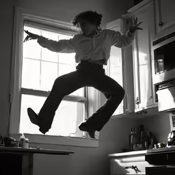 a woman is jumping into the air in a kitchen