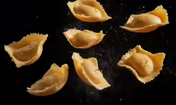 a pile of dumplings on top of a black surface