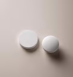two round white dishes sitting on a table