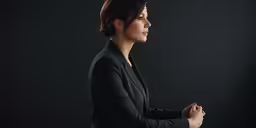 woman wearing black outfit standing in front of dark background
