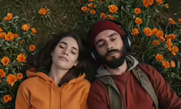 there is a man and woman that are laying in the grass