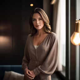 a beautiful woman in an elegant outfit standing near a window