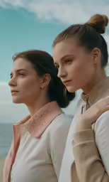 two women stand beside each other with one being ponytailed up