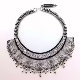 a silver necklace made of three chains with tassels on each end,a silver and black collar necklace with pearls, beads and beads