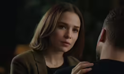 the woman is talking to the man in the dark
