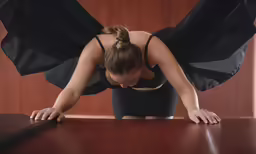 the woman is sitting down while bent over the table
