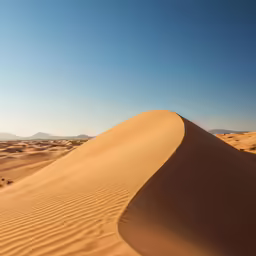 the dunes and mountains are dotted by sand dunes
