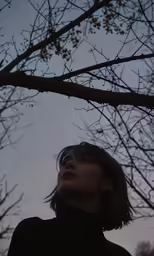 a woman standing next to a tree in the air