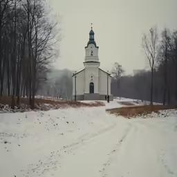 a small church with a clock on it in the middle of a snow covered road