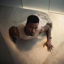 a man is lying on the floor and looking at camera