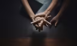 two hands together, on top of the table