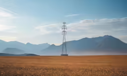 a telephone pole stands in the middle of an empty field