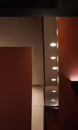 a hallway has red walls and two different lighting fixtures