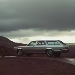 an automobile that is sitting on a dirt road