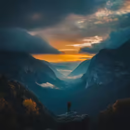 a person stands on top of a mountain looking into the valley