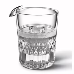 a shot glass with a silver handle and ice in the center