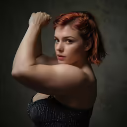 a beautiful redhead woman posing with her arm behind her head