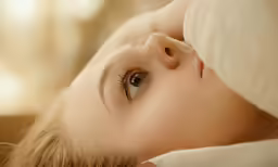 an eye that looks like she is laying on the pillow