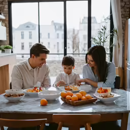 a family sitting at the table and eating