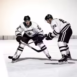 two men wearing helmets playing on ice