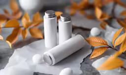 three bottles with lids are sitting on wax paper