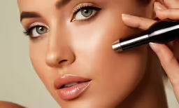 a woman putting mascara on her lips