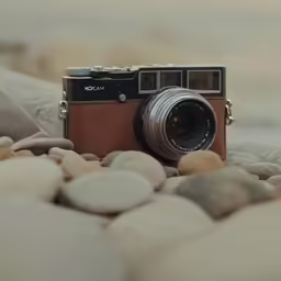 an old camera on rocks next to the ocean