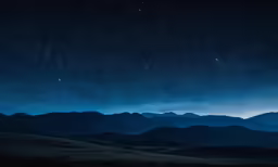 a view of mountains in the distance and night sky above